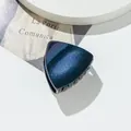 Detailed view of a dark blue glitter cat ear hair claw clip with black shark teeth grip - Dark Blue