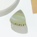 Primer plano de una pinza de pelo verde claro con purpurina y textura de lentejuelas - Verde