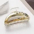 Macro detail of marble pattern hair claw clip with black artistic calligraphy decoration - Yellow