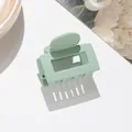 Detail of a matte bean green rectangular hair claw clip with a refined frosted finish - Green