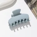 Macro detail of a small matte light blue hair claw clip on a stylish white tray - Sky Blue
