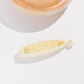 Détail d'une pince banane en résine blanc cassé avec double rangée de dents imbriquées - Blanc Cassé
