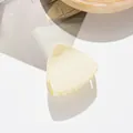 Vista detallada de pinza para el cabello mate crema en forma de triángulo sobre fondo blanco - Blanco Roto