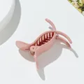 Vista detallada de pinza para el cabello rosa con dientes curvos y resorte de metal - Rosa