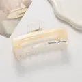 Detail of a rectangle claw clip with shell texture and Barrette La France lettering - Yellow