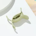 Detalle de una pinza de pelo verde claro brillante con purpurina perlada en fondo blanco - verde claro