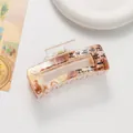 Detail of an amber acetate hair claw with Chinese calligraphy in New Chinese style - Brown