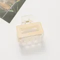 Detail of transparent cream hair claw clip with Barrette La France gold spring accent - Off-white