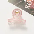 Dettaglio macro della molletta per capelli rosa perlato con trama acrilica lucida - Rosa