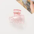 Detalle de una pinza para el pelo rosa translúcida con acabado brillante en fondo blanco - Rosa