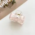 Dettaglio della molletta a farfalla rosa iridescente con elegante perla bianca - Rosa