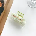 Close-up of translucent green clover hair claw clip with colorful rhinestones details - Yellow-Green