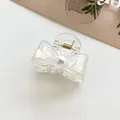Dettaglio del fermaglio per capelli a farfalla iridescente con perla e molla dorata - Bianco