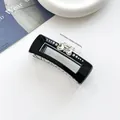 Détail d'une pince à cheveux cœur noire élégante avec strass et mécanisme à ressort métal - Noir