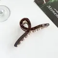 Dettaglio ravvicinato della grande pinza per capelli marrone con trama a rombi trapuntata - Marrone scuro