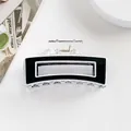 Dettaglio di un fermaglio per capelli rettangolare bianco e nero su una scrivania minimal - Nero