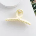 Détail d'une grande pince à cheveux mate crème avec un design croisé infini élégant - 11cm / Blanc