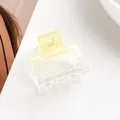 Macro detail of a transparent yellow square hair claw clip with a silver metal spring - Yellow