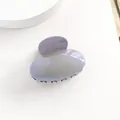 Primo piano di mini molletta per capelli ovale perlata con sfumatura viola su sfondo bianco - Grigio