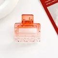Macro detail of square hair claw clip with orange gradient finish and metal spring - Orange
