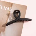 Dettaglio ravvicinato di una pinza per capelli nera opaca su uno sfondo di rivista di moda - 11cm / Nero