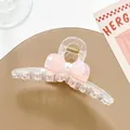 Dettaglio della pinza per capelli trasparente con fiocco rosa, perla e molla dorata - Rosa