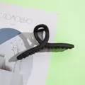 Gros plan d'une pince à cheveux noire mate de 13 cm avec un design torsadé épuré - 13cm / Style Torsadé Croisé / Noir