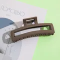 Dettaglio di una pinza per capelli rettangolare marrone opaco su una rivista - 11.5cm / Stile Rettangolare Traforato / Caffè