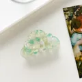 Draufsicht auf eine wolkenförmige mint- und cremefarbene Acetat-Haarklammer mit Marmorierung - Grün
