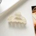 Detailed close-up of a small cream white marble acetate claw clip on a clean display card - Off White
