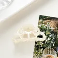 Detail of cream white acetate hair claw clip with pearl luster and cloud edge design - Off White
