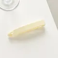 Detalle de la pinza de banana crema que muestra los dientes internos y el acabado liso - Blanco Roto