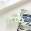 Detail of light green marble acetate hair claw clip with cloud wave hollow design - Green