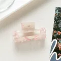 Close-up of a pink and white marbled acetate rectangular hair claw clip for elegant styles - Pink