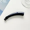 Macro detail of dark blue glitter banana hair clip with high-gloss resin finish - Navy Blue