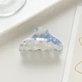 Dettaglio di un mollettone in acetato floreale con finitura perlata in blu e bianco - Celeste