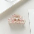 Macro detail of wave-shaped pink and cream acetate hair claw clip with marble texture - Pink