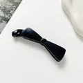 Détail macro d'une pince à cheveux nœud bleu foncé avec texture scintillante étoilée - Bleu foncé