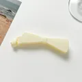 Vue détaillée de la barrette banane nœud élégante en résine crème au fini lisse et brillant - Blanc Cassé