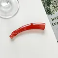 Vista superior de una pinza de pelo tipo banana rojo coral sobre un fondo blanco - Rosa oscuro