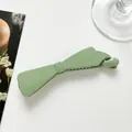 Glossy light green banana hair clip with minimalist bow design on a white background - Green