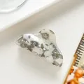 Detail einer floralen Acetat-Haarklammer mit grauem Marmormuster auf weißem Tisch - Grau