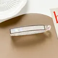 Detail of a large pearlescent banana hair clip with transparent teeth on leather - Dark Gray