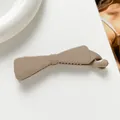 Détail d'une pince banane nœud beige mat avec dents internes sur un fond minimaliste - Kaki clair