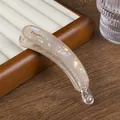 Detalle de la pinza de banana iridiscente con letras doradas France y dientes antideslizantes - Caqui