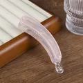 Detalle de la pinza banana rosa iridiscente con textura de mármol y letras France - Rosa