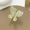 Detailed macro of a hollow butterfly hair claw clip with pearlescent finish and metal spring - Green