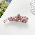 Macro detail of the light pink resin banana hair clip with flowers and sparkling rhinestones - Pink