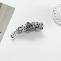 Detail view of marble pattern banana clip with 3D floral accent and rhinestones - Gray
