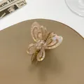 Vista dettagliata del fermaglio a farfalla traforato con finitura rosa perlato su pelle - Marrone